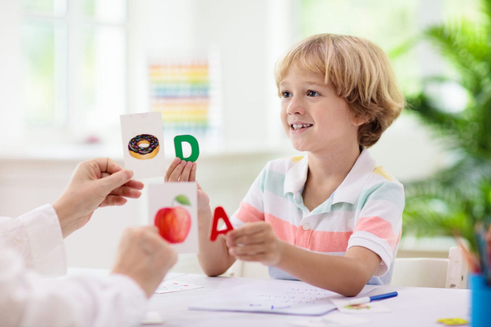 Boy learning letters with flashcards.